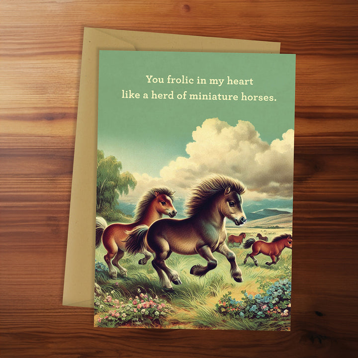 Greeting card with miniature horses on a wooden surface