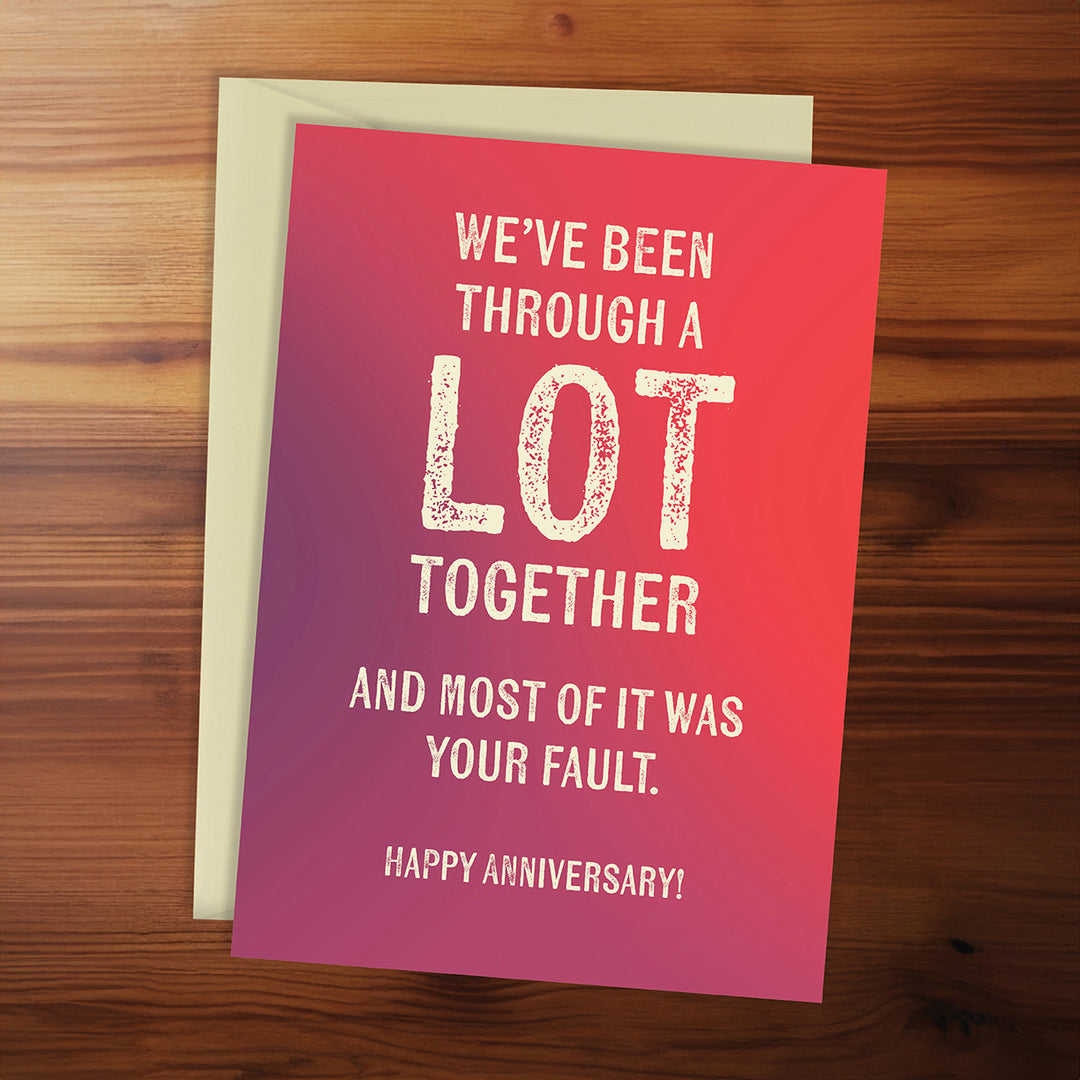Card with humorous anniversary message on a wooden surface