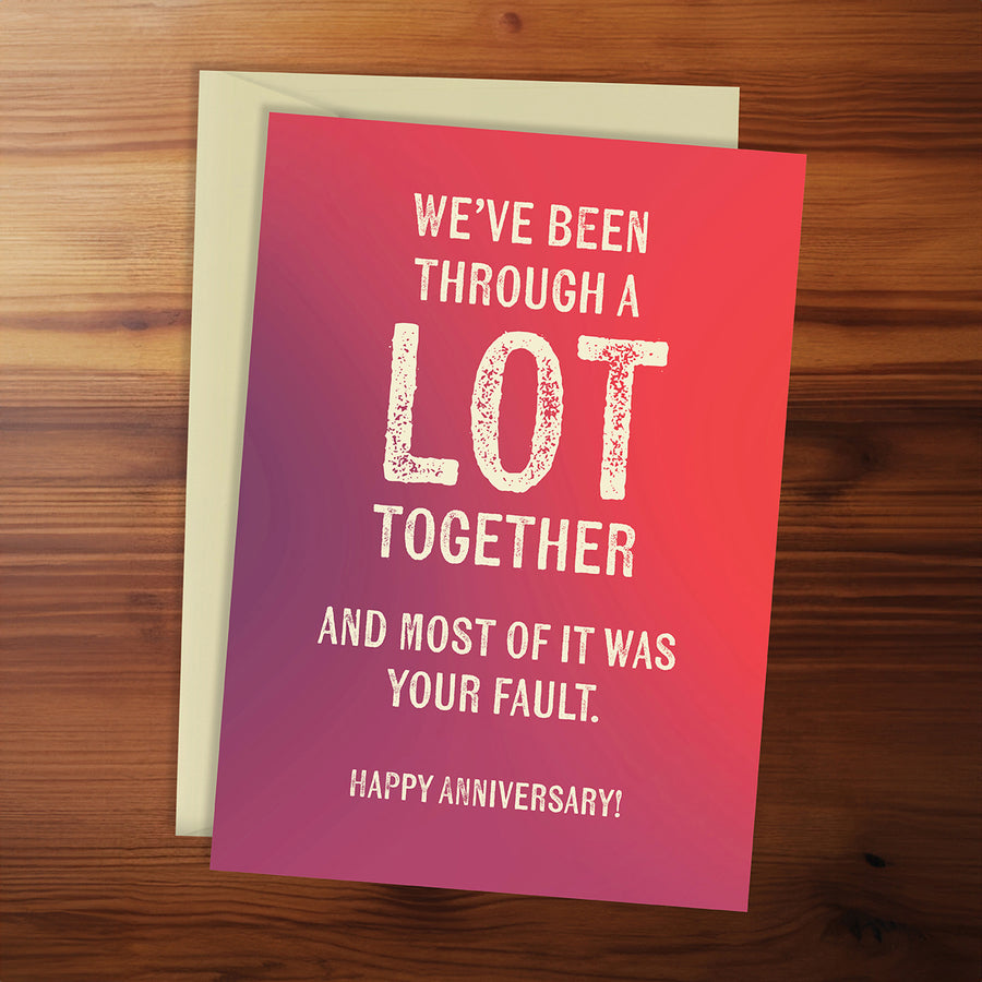 Card with humorous anniversary message on a wooden surface