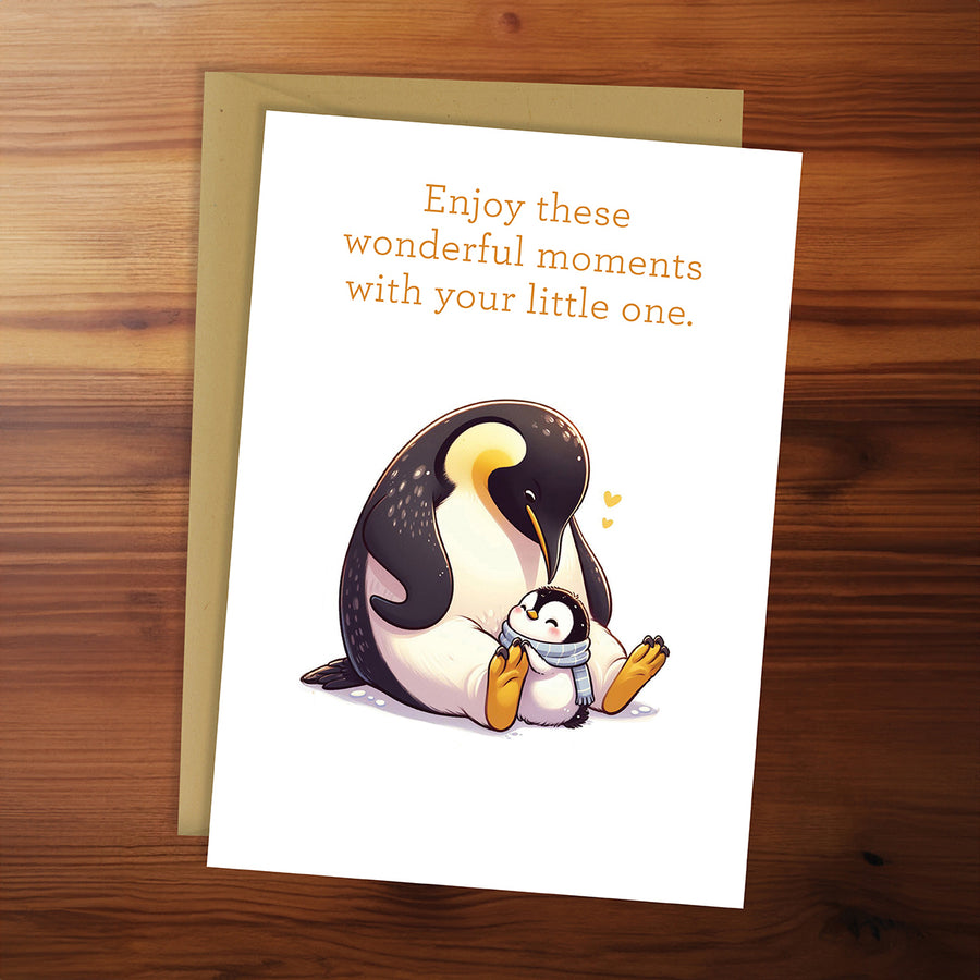 Card with penguin illustration and text on a wooden surface