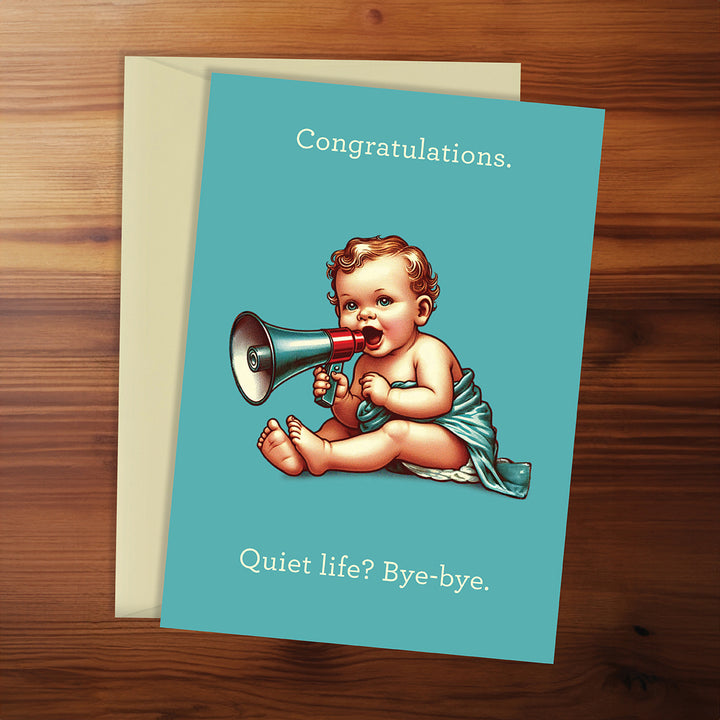 Greeting card with baby holding a megaphone on a wooden surface