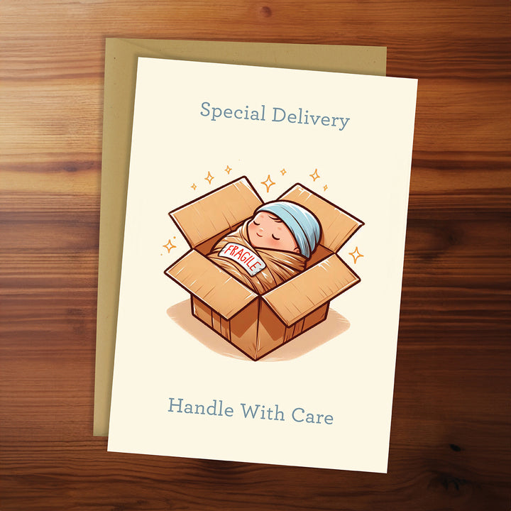 Greeting card with a baby in a box illustration on a wooden surface