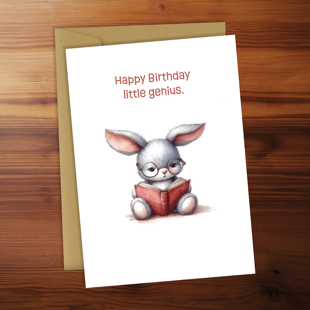 Greeting card with a cartoon rabbit reading a book on a wooden surface