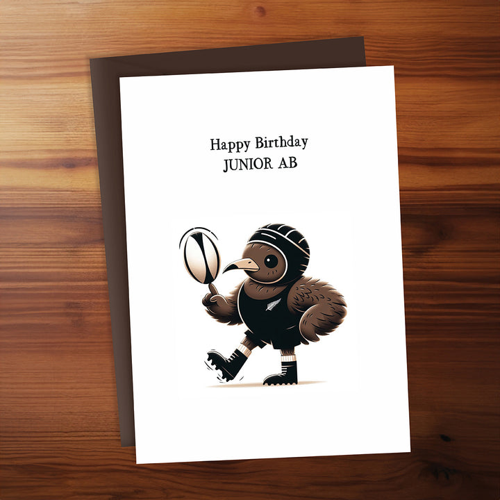 Birthday card with a cartoon turkey holding a rugby ball on a wooden surface
