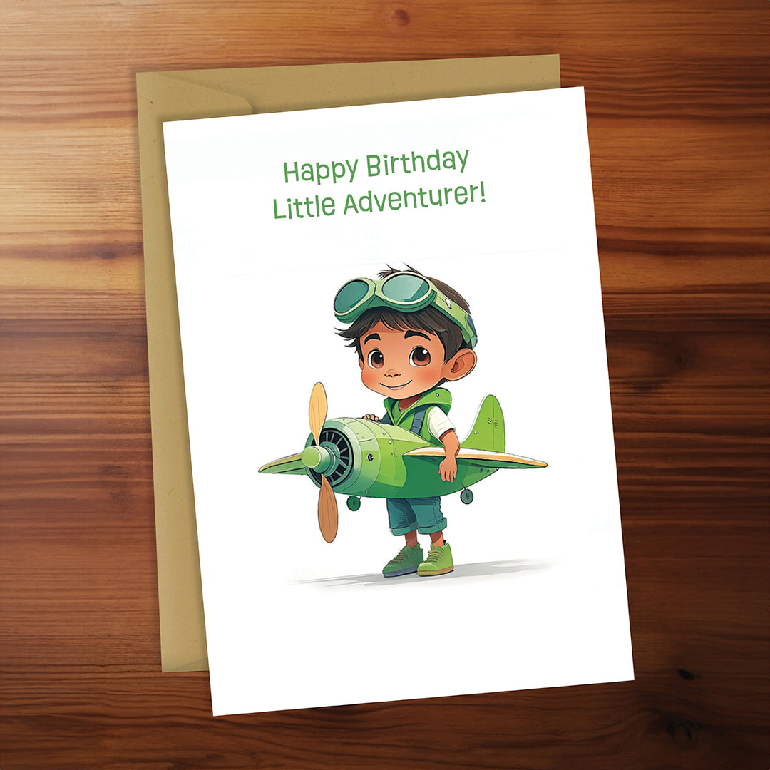 Birthday card with a child holding a green airplane on a wooden surface