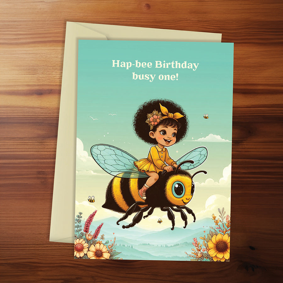 Birthday card with a child riding a bee on a wooden surface