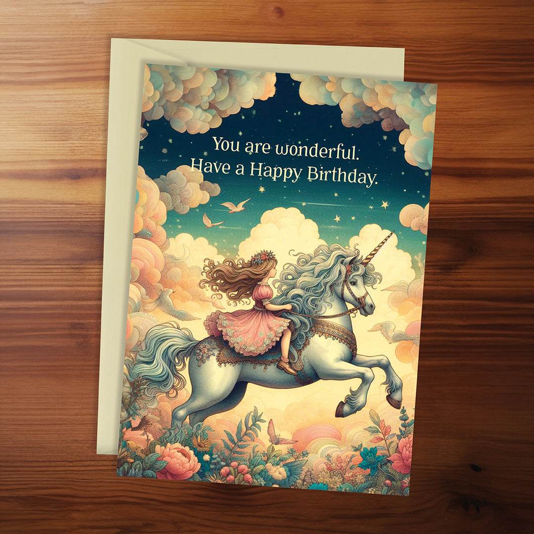 Greeting card with a fairy riding a unicorn on a wooden surface