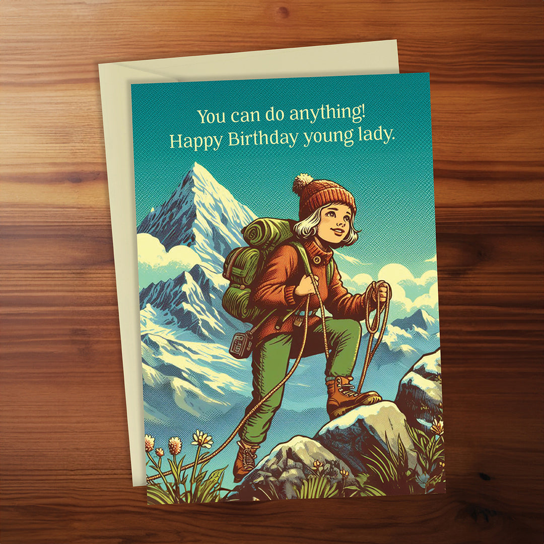 Birthday card with a hiker in mountains on a wooden surface