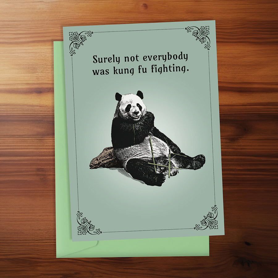 Greeting card with panda illustration and humorous text on a wooden surface