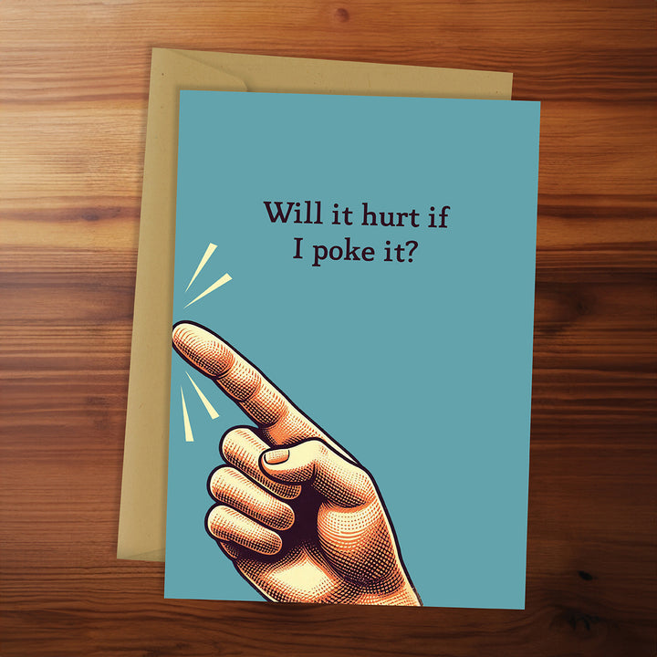 Card with a hand pointing and text 'Will it hurt if I poke it?' on a wooden surface