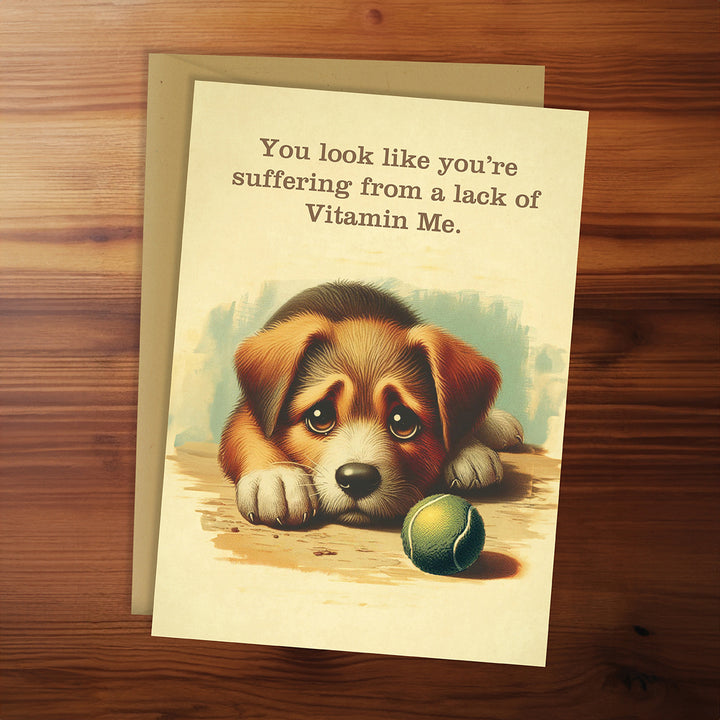 Greeting card with a puppy illustration and humorous text on a wooden surface