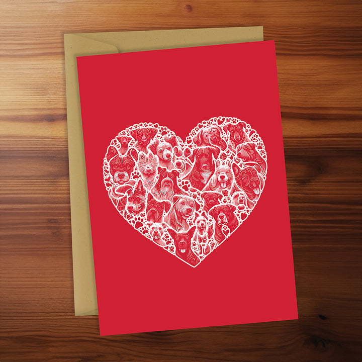 Red card with a white heart-shaped design of dogs on a wooden surface