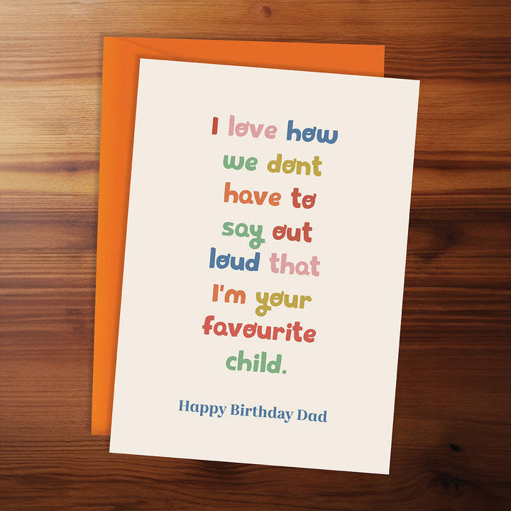 Birthday card for dad with colorful text on a wooden surface