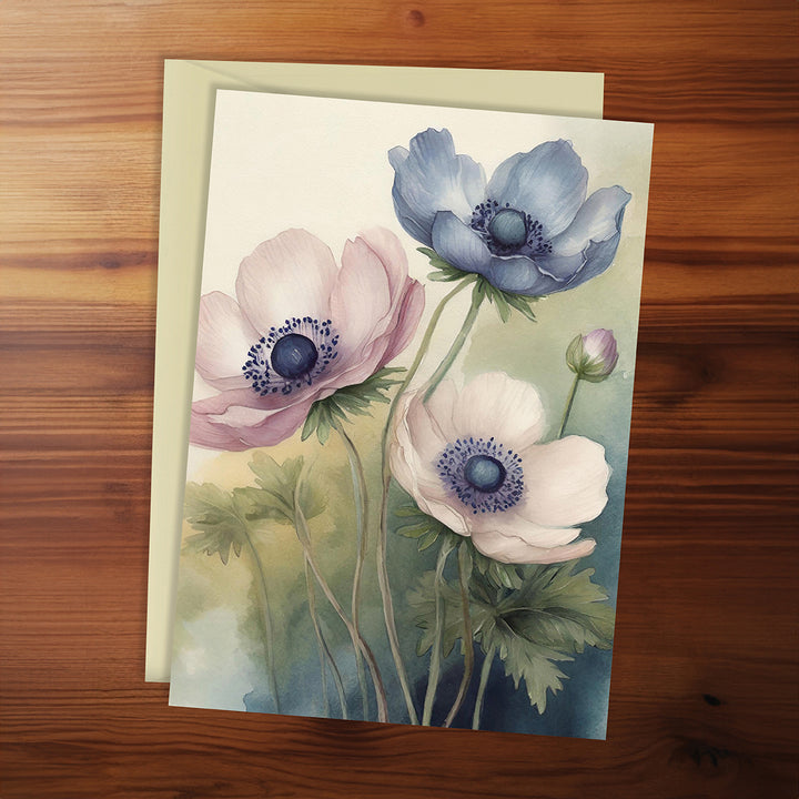 Floral card with pink, blue, and white flowers on a wooden surface