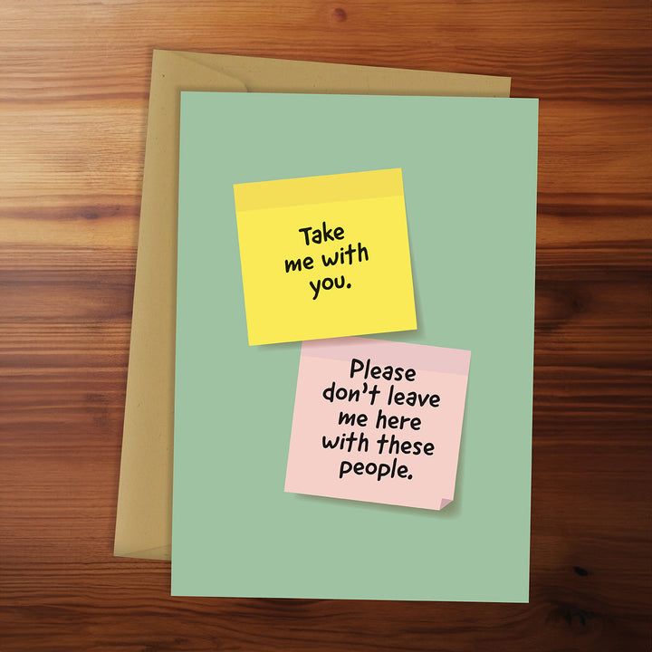 Green card with yellow and pink sticky notes on a wooden surface