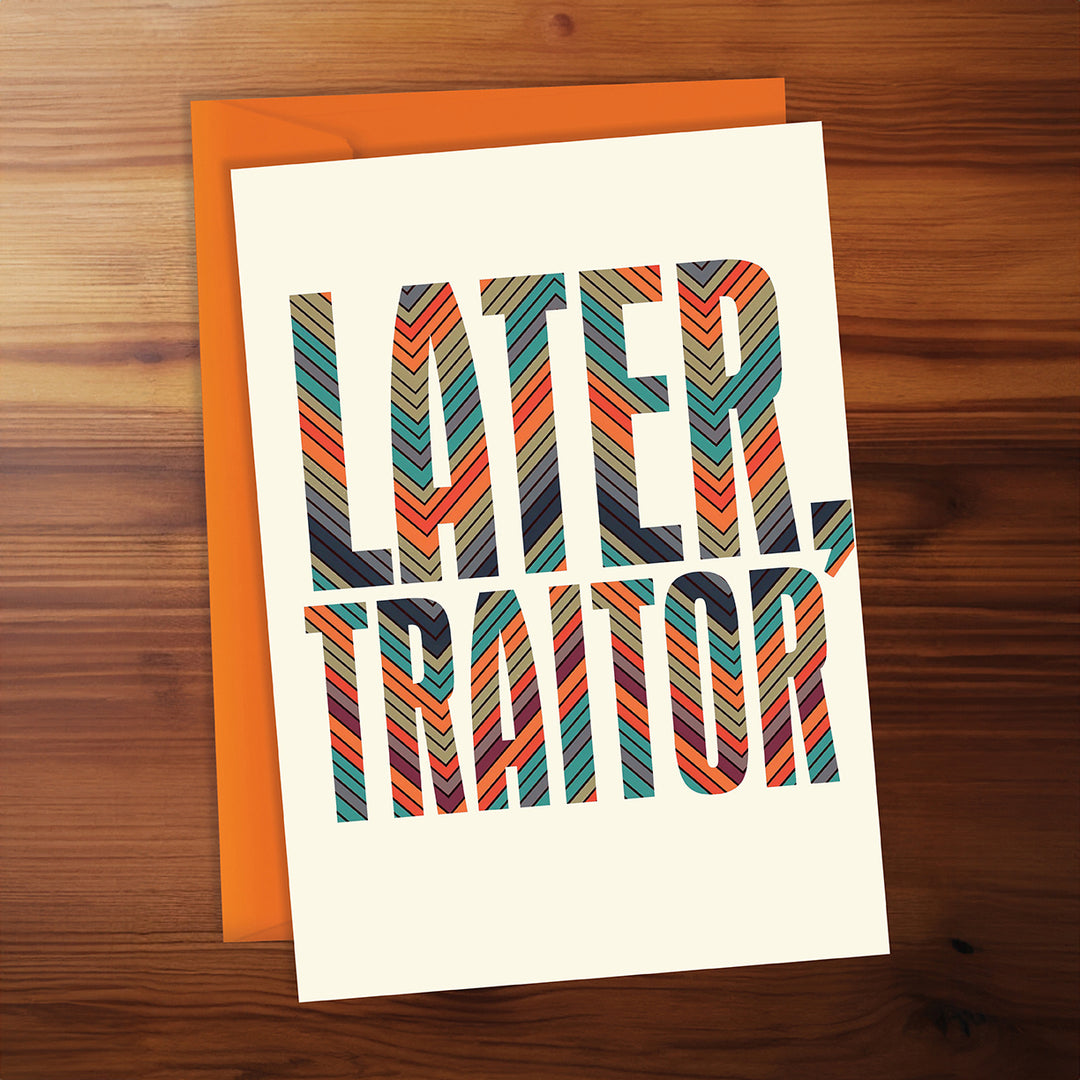 Greeting card with 'LATER, TRAITOR' text on a wooden surface