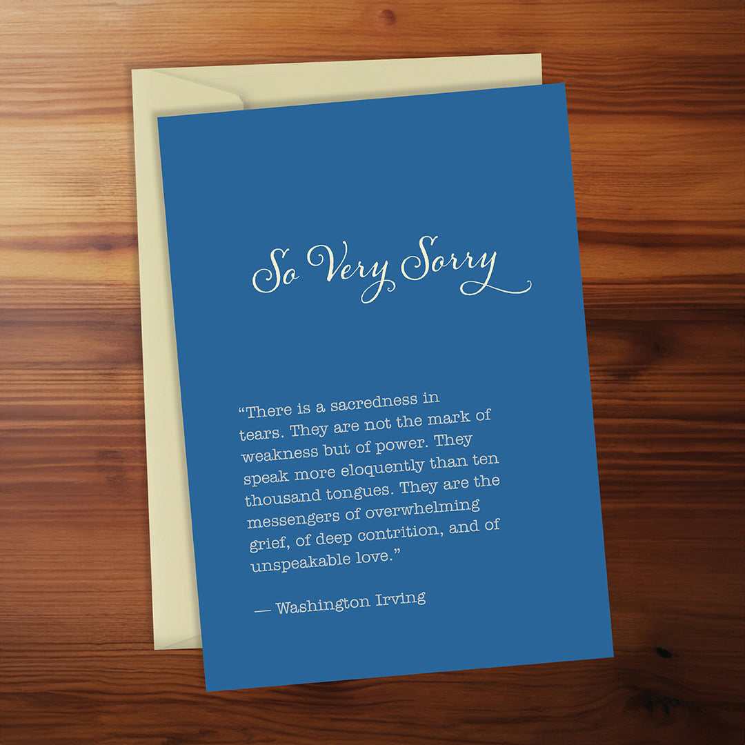 Blue card with text and envelope on a wooden surface