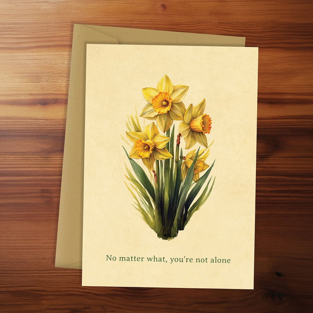 Greeting card with yellow daffodils and motivational text on a wooden surface