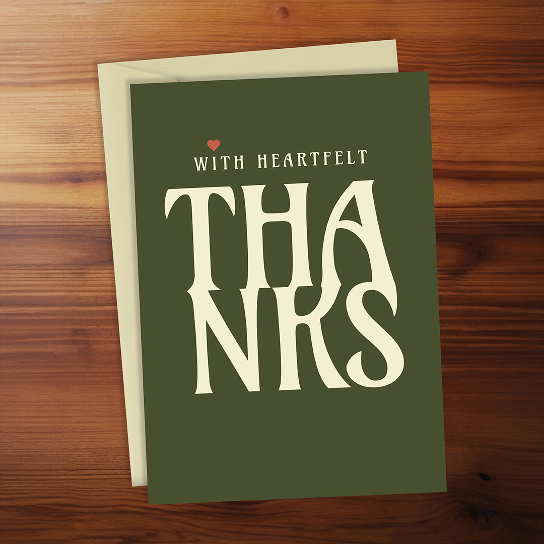 Green card with 'THANKS' and 'WITH HEARTFELT' text on a wooden surface