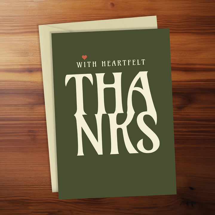 Green card with 'THANKS' and 'WITH HEARTFELT' text on a wooden surface