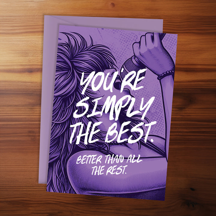 Purple card with text 'You're simply the best. Better than all the rest.' on a wooden surface